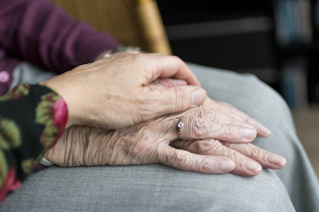 deux personnes âgées se tiennent la main après avoir signé un contrat de viager